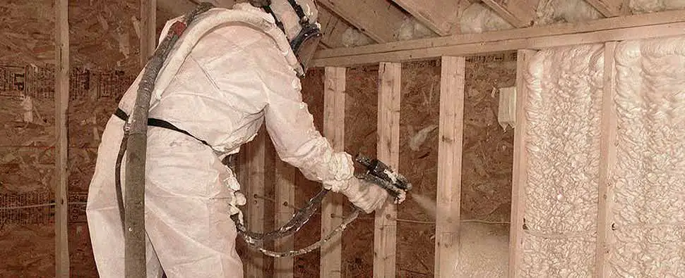 Spraying foam insulation into the walls of a new construction